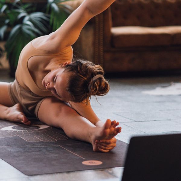 Person stretching in a well-lit room, demonstrating flexibility.